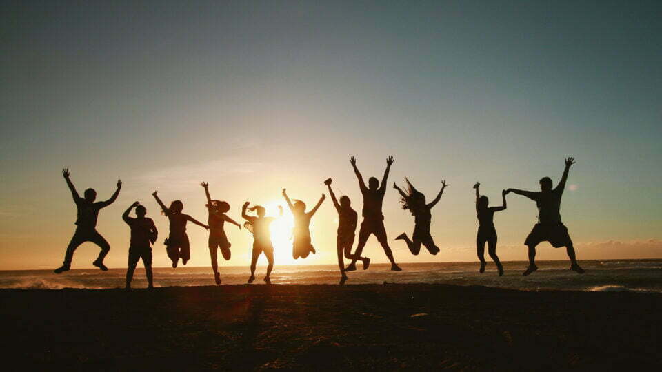 un gruppo di giovani che si lanciano in aria al tramonto
